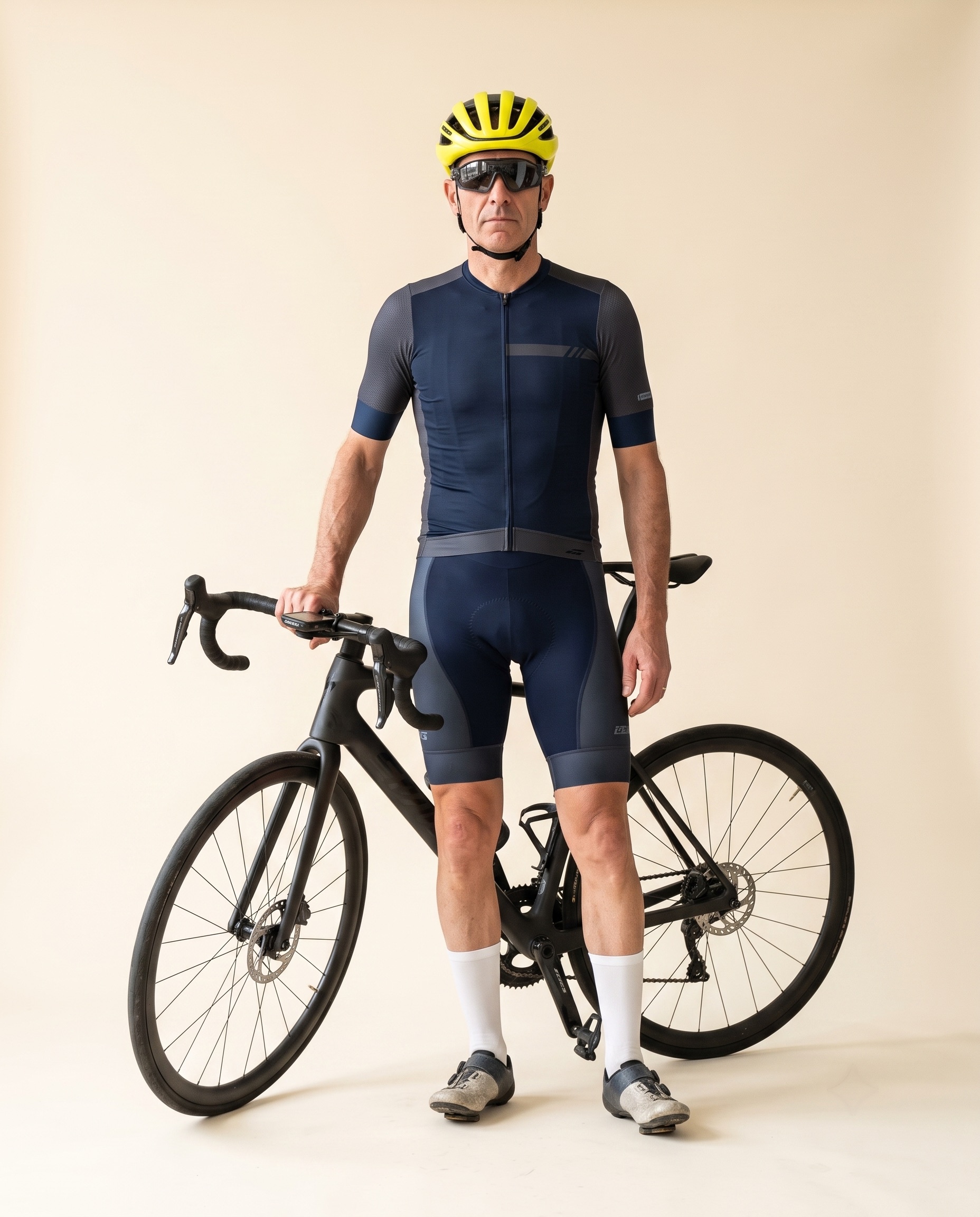 Portrait studio : cycliste du dimanche en tenue World Tour complète, casque aéro jaune, à côté de son vélo carbone